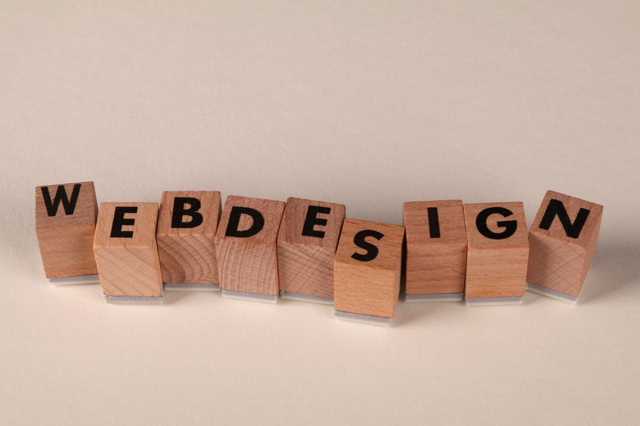 Des blocs de bois formant web design illustrent de manière créative le concept de design numérique.
